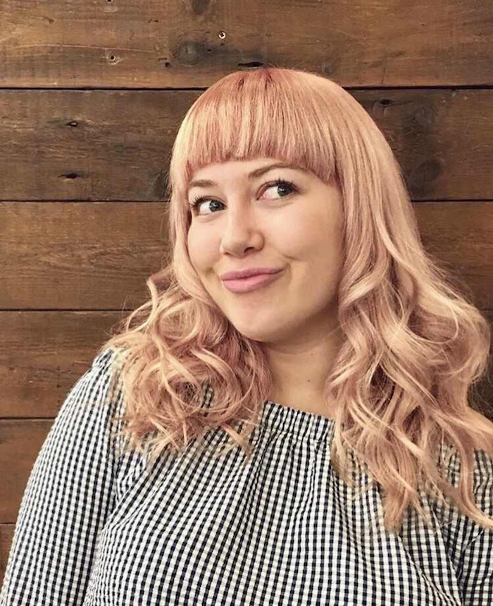 Light peach hair with a fringe and waves against a wood background